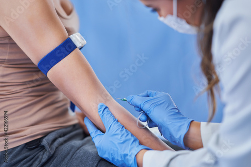 Female patient having blood sample drawn in a lab