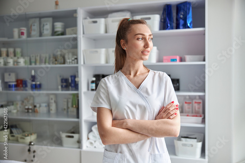 Pretty confident  professional female doctor in cosmetoloy cabinet