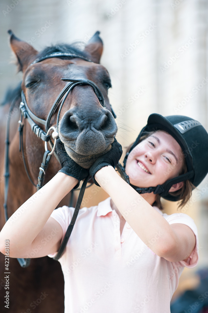 Portrait of funny chestnut horse snout on girl's coach palms