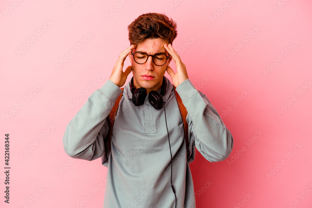 Young student man isolated on pink background touching temples and having headache. Young student man isolated on pink background touching temples and having headache.