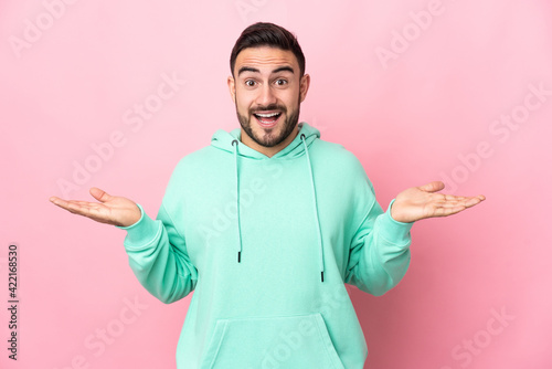 Young caucasian handsome man isolated on pink background with shocked facial expression © luismolinero