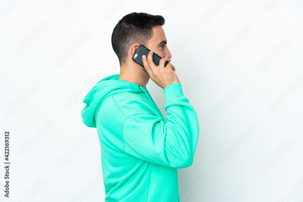 Young caucasian handsome man isolated on white background keeping a conversation with the mobile phone with someone Young caucasian handsome man isolated on white background keeping a conversation with the mobile phone with someone
