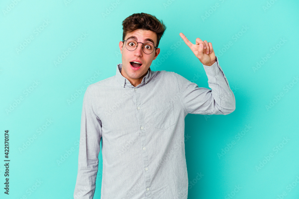 Young caucasian man isolated on blue background having some great idea, concept of creativity.