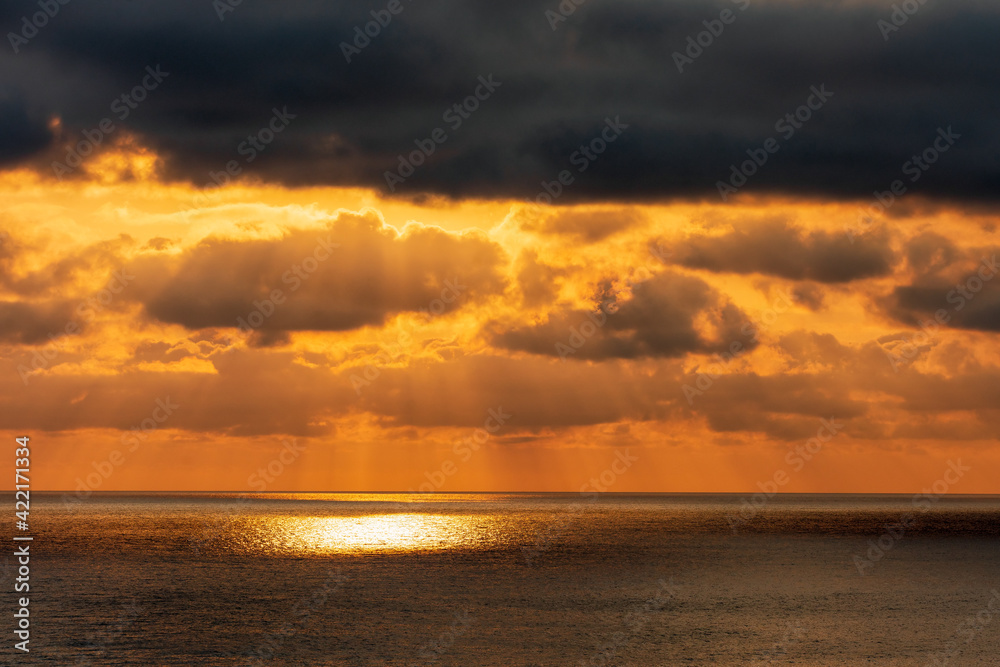 Dramatic sunset at Black Sea. Beautiful seascape of sun rays, scenic sky and clouds.