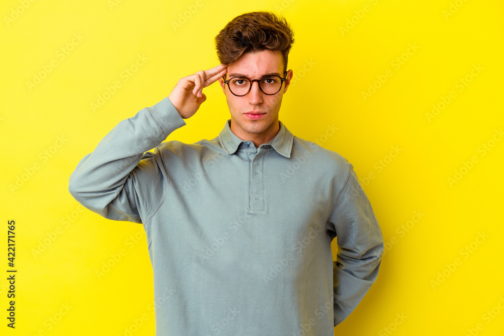 Young caucasian man isolated on yellow background pointing temple with finger, thinking, focused on a task. Young caucasian man isolated on yellow background pointing temple with finger, thinking, focused on a task.