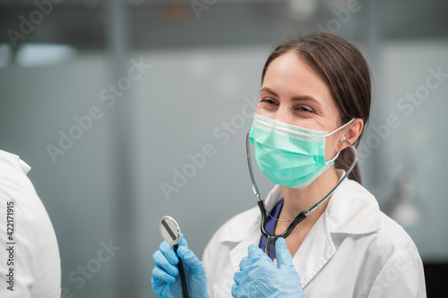 An experienced doctor girl conducts a patient s appointment in her office  she laughs.