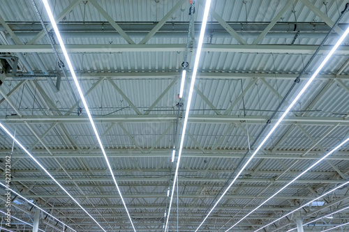 Lamps with diode lighting under the ceiling of a modern warehouse or shopping center. Engineering of the ceiling lighting of the stadium or exhibition hall.
