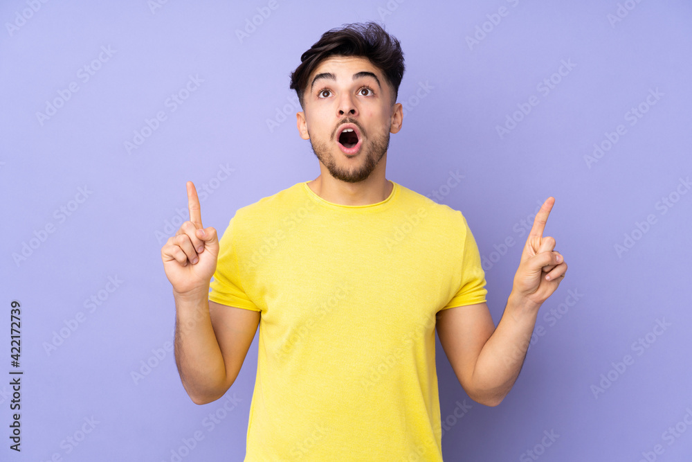 Arabian handsome man over isolated background surprised and pointing up Arabian handsome man over isolated background surprised and pointing up