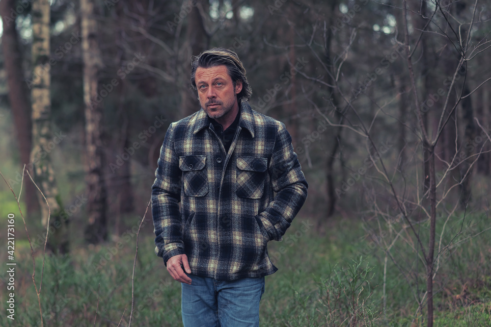 Cool man in checkered coat in the woods. Cool man in checkered coat in the woods.
