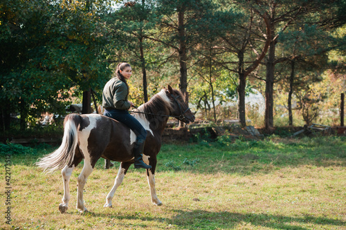On a warm autumn day, a young girl went out to ride her mare on horseback around the farm.