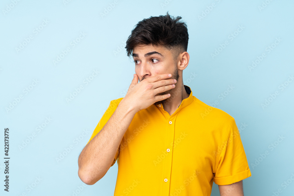 Arabian handsome man over isolated background doing surprise gesture while looking to the side Arabian handsome man over isolated background doing surprise gesture while looking to the side