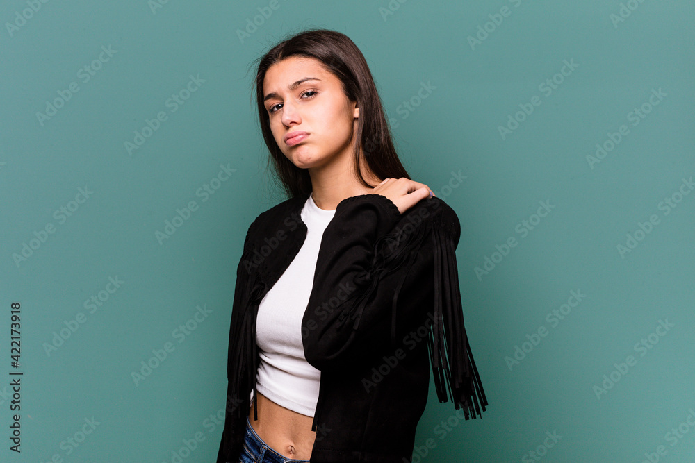 Young Indian woman isolated on blue background having a shoulder pain. Young Indian woman isolated on blue background having a shoulder pain.