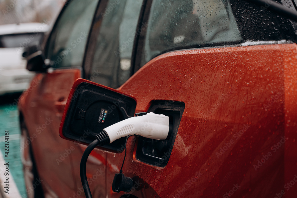Electric car with power cable supply plugged in Electric car with power cable supply plugged in