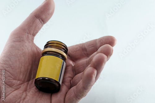 in the hand of an  senior man a bottle of pills