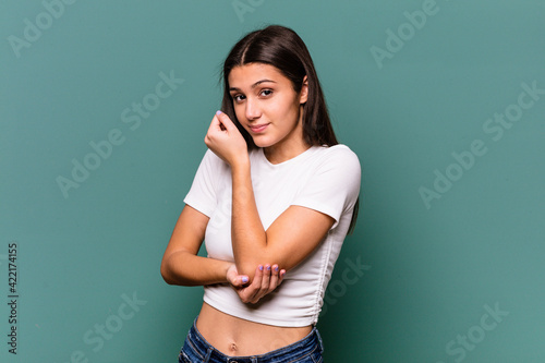 Young Indian woman isolated on blue background confused, feels doubtful and unsure.