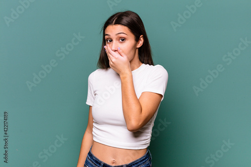 Young Indian woman isolated on blue background scared and afraid.