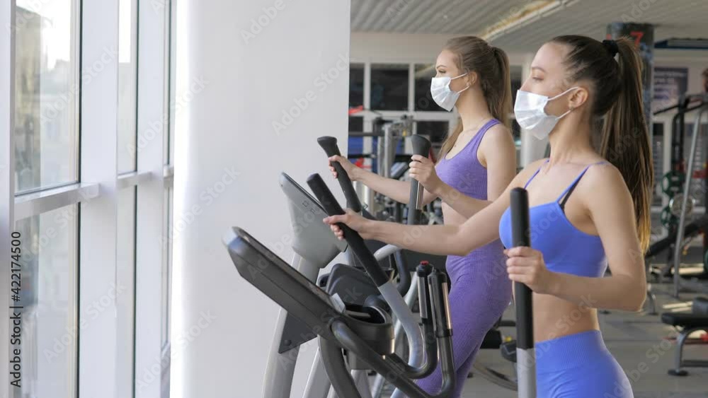 Beautiful sport girls are engaged on a simulator in the gym. Achieving goals, sports motivation Beautiful sport girls are engaged on a simulator in the gym. Achieving goals, sports motivation