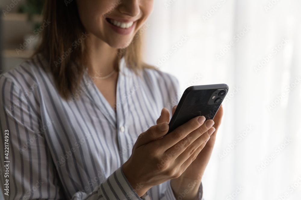 Close up smiling woman holding phone, typing on screen, writing message or surfing internet, happy young female using smartphone, having fun with gadget, browsing apps, enjoying leisure time Close up smiling woman holding phone, typing on screen, writing message or surfing internet, happy young female using smartphone, having fun with gadget, browsing apps, enjoying leisure time