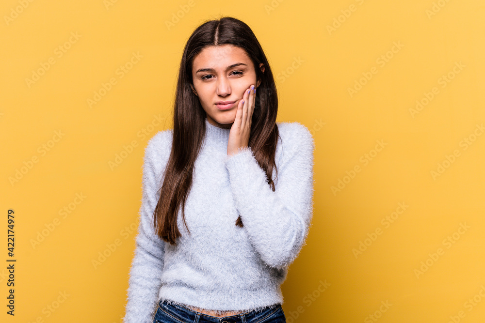 Young Indian woman isolated on yellow background having a strong teeth pain, molar ache. Young Indian woman isolated on yellow background having a strong teeth pain, molar ache.