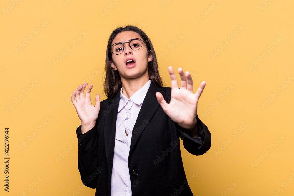 Young Indian business woman isolated on yellow background being shocked due to an imminent danger Young Indian business woman isolated on yellow background being shocked due to an imminent danger