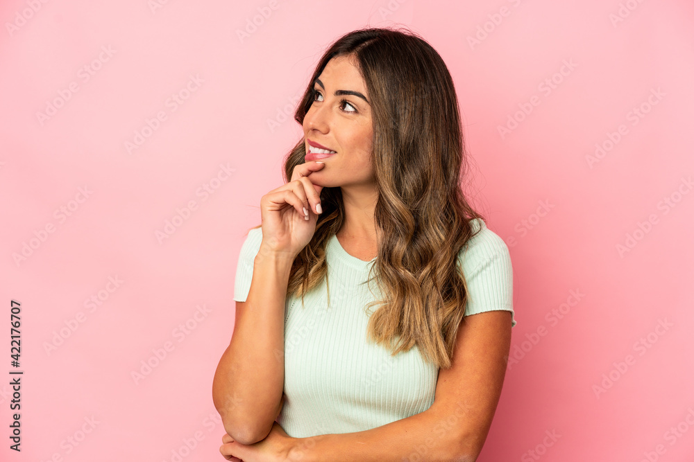 Young caucasian woman isolated relaxed thinking about something looking at a copy space. Young caucasian woman isolated relaxed thinking about something looking at a copy space.