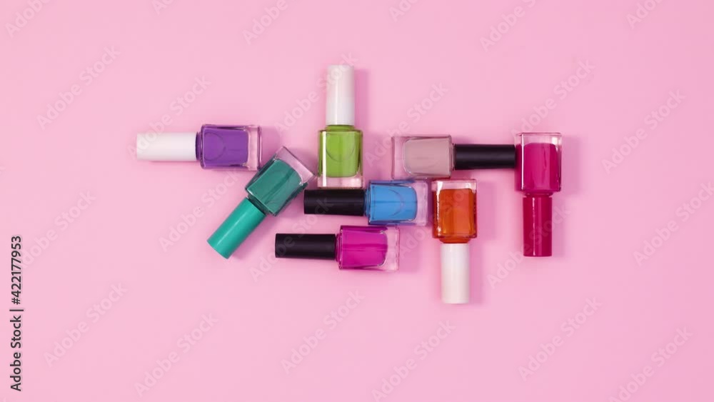 Creative composition of nail polish bottles ordered on bright pink background. Stop motion flat lay Creative composition of nail polish bottles ordered on bright pink background. Stop motion flat lay