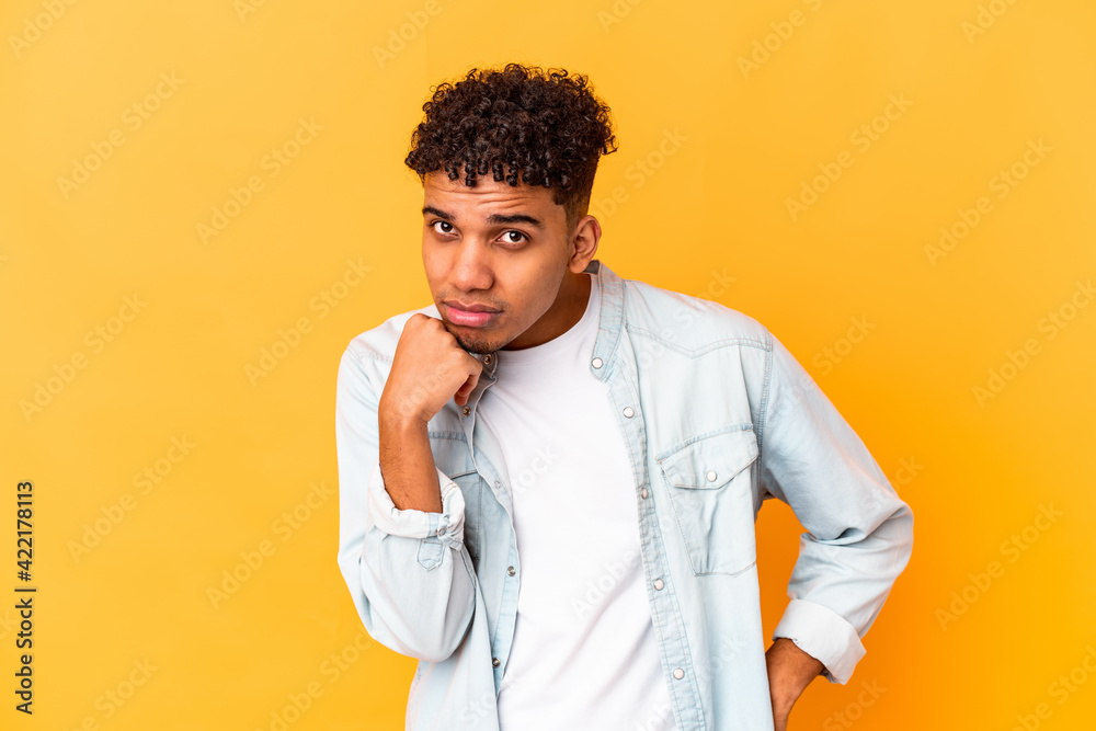 Young african american curly man isolated on purple who feels sad and pensive, looking at copy space. Young african american curly man isolated on purple who feels sad and pensive, looking at copy space.