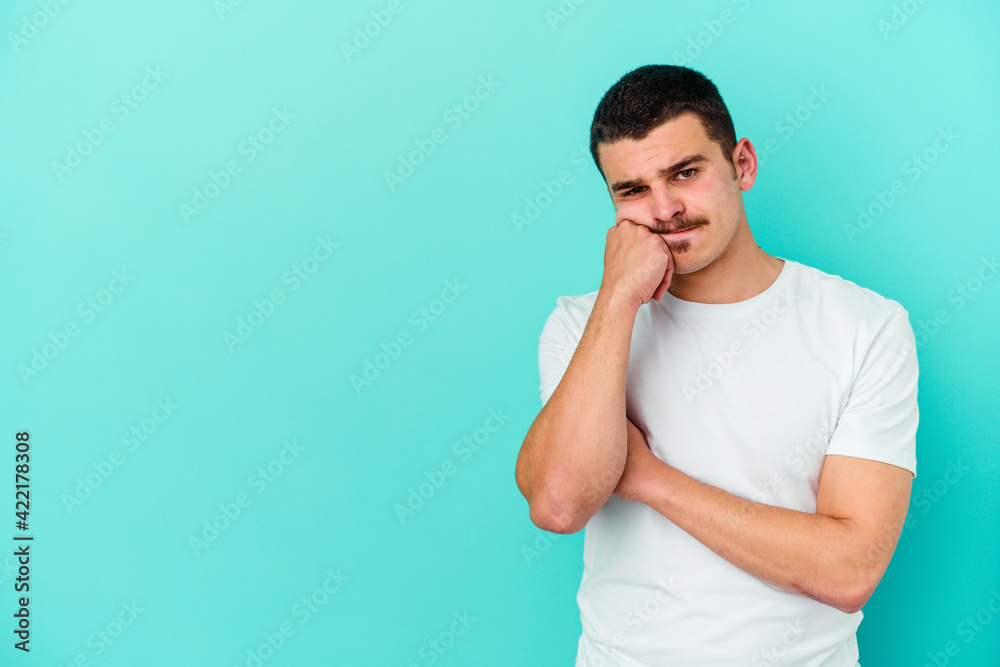 Young caucasian man isolated on blue background who feels sad and pensive, looking at copy space. Young caucasian man isolated on blue background who feels sad and pensive, looking at copy space.