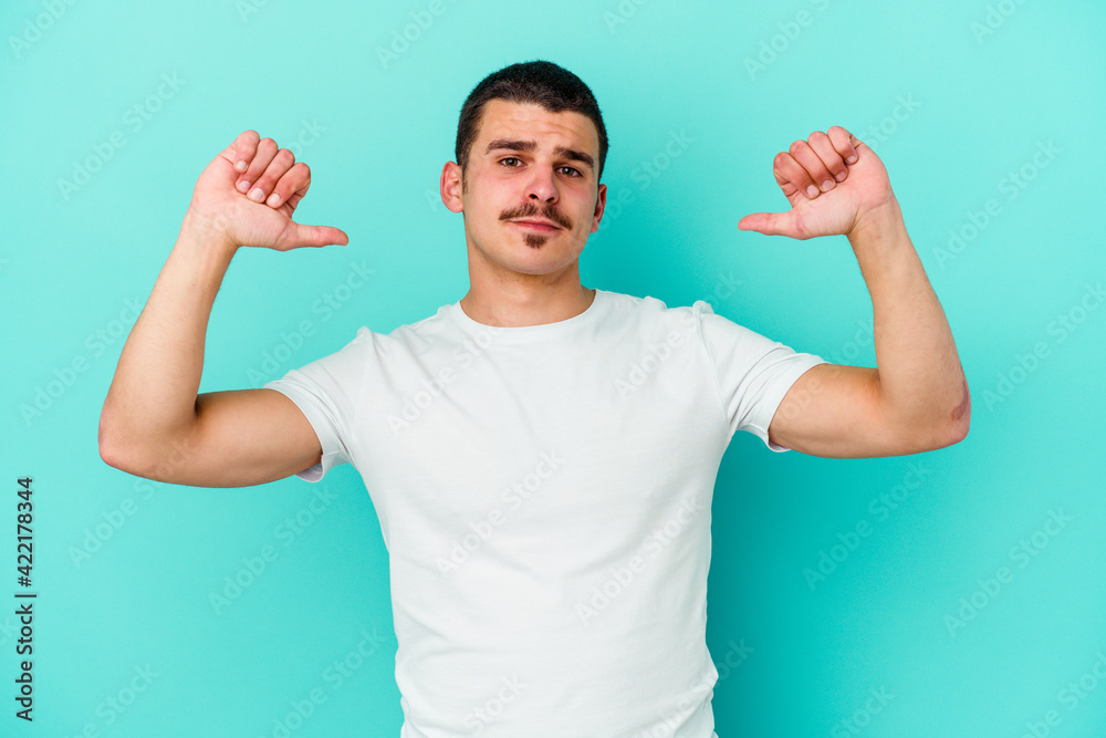 Young caucasian man isolated on blue background feels proud and self confident, example to follow. Young caucasian man isolated on blue background feels proud and self confident, example to follow.