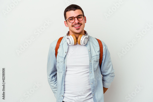 Young caucasian student man listening to music isolated on white background happy, smiling and cheerful.