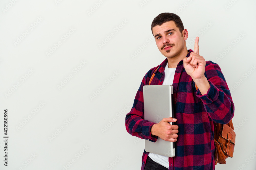 Young caucasian student man holding a laptop isolated on white background showing number one with finger. Young caucasian student man holding a laptop isolated on white background showing number one with finger.