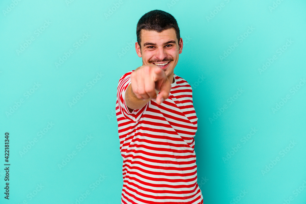 Young caucasian man isolated on blue background pointing to front with fingers. Young caucasian man isolated on blue background pointing to front with fingers.