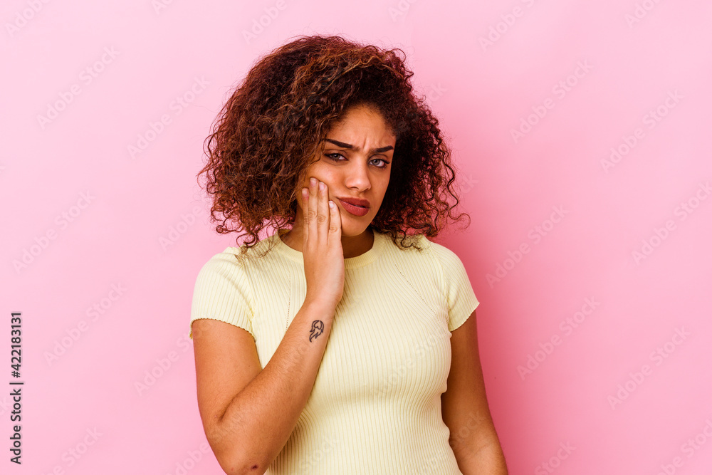 Young african american woman isolated on pink background having a strong teeth pain, molar ache.