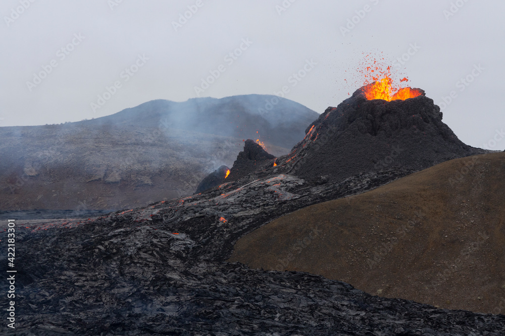 GELDINGADALIR, ICELAND - MARCH 21, 2021: A small volcanic eruption started at the Reykjanes peninsula. The event has attracted thousands of visitors who have braved a daring hike to the crater.