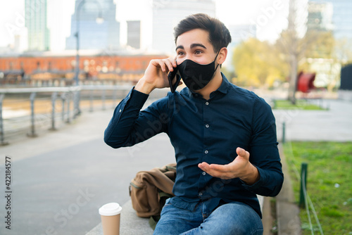 Young man talking on the phone outdoors.