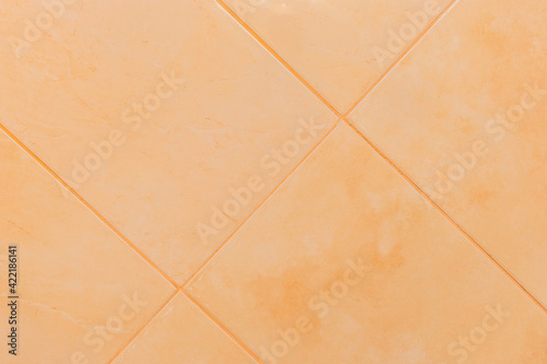 Orange ceramic tile floor or wall in bathroom texture background © Andrey