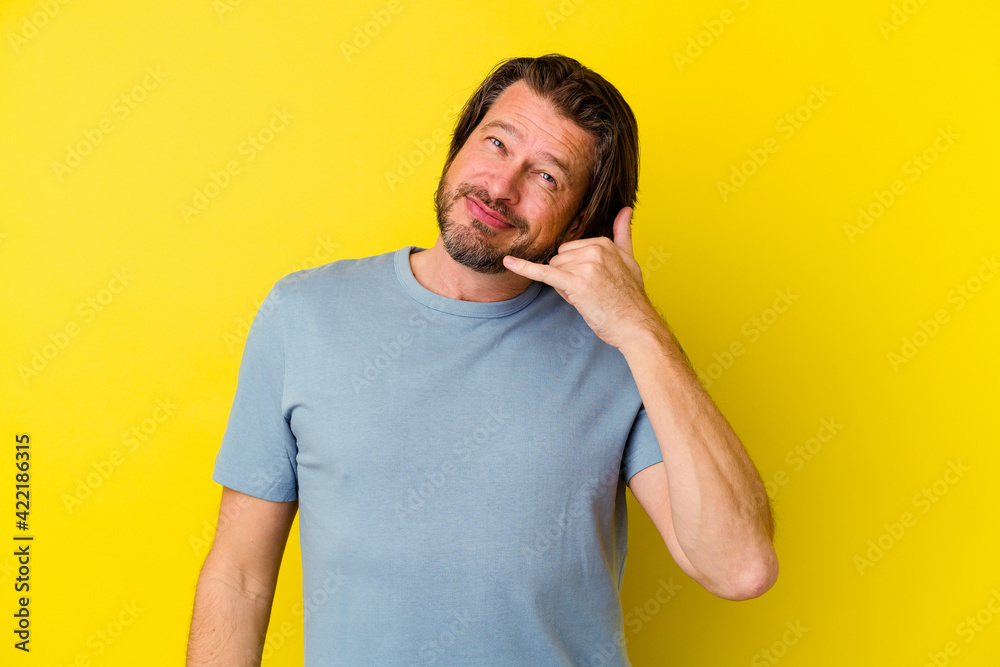 Fototapeta premium Middle age caucasian man isolated on yellow background showing a mobile phone call gesture with fingers.
