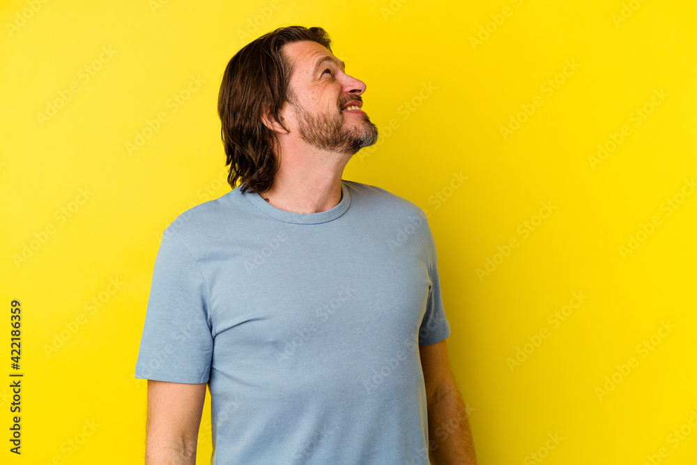 Middle age caucasian man isolated on yellow background relaxed and happy laughing, neck stretched showing teeth. Middle age caucasian man isolated on yellow background relaxed and happy laughing, neck stretched showing teeth.