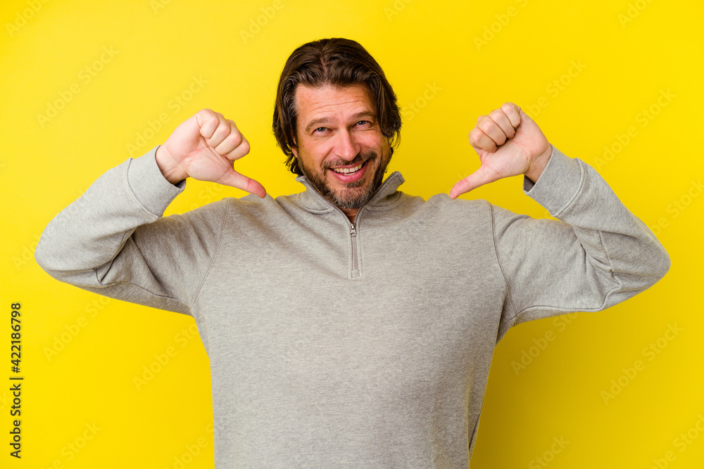 Middle age caucasian man isolated on yellow background feels proud and self confident, example to follow. Middle age caucasian man isolated on yellow background feels proud and self confident, example to follow.