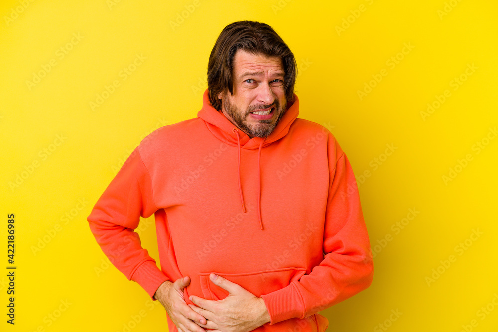 Middle age caucasian man isolated on yellow background having a liver pain, stomach ache. Middle age caucasian man isolated on yellow background having a liver pain, stomach ache.