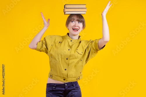 Woman with books on her hea...