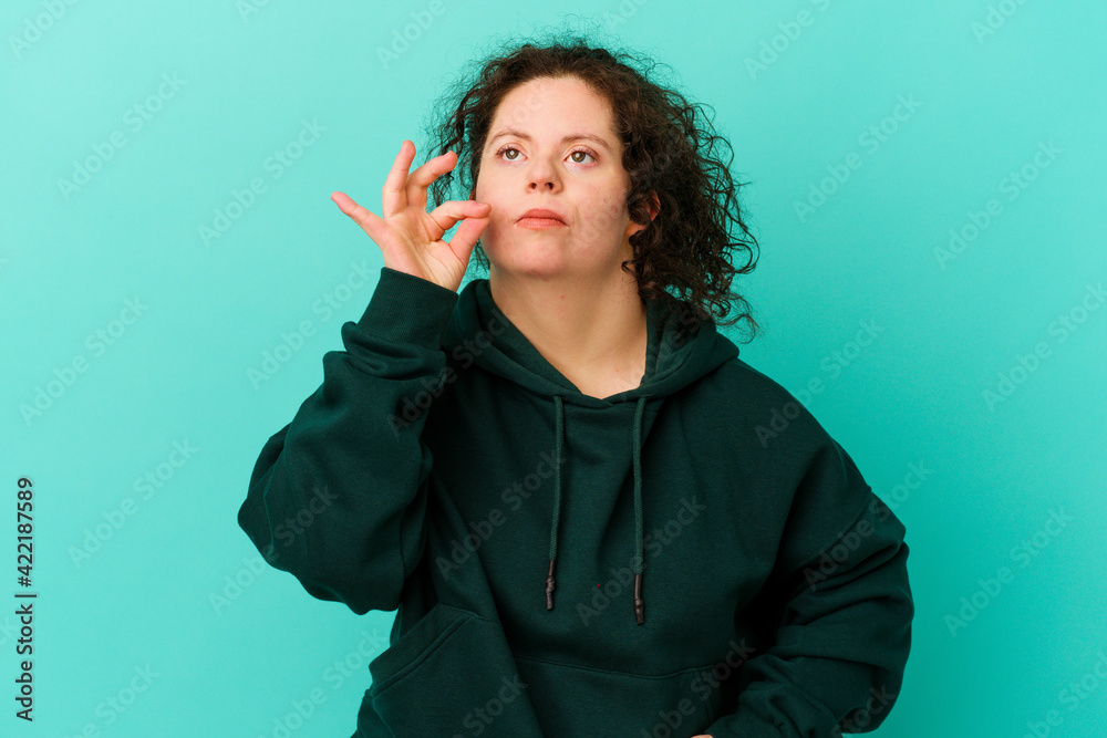 Obraz premium Woman with Down syndrome isolated with fingers on lips keeping a secret.