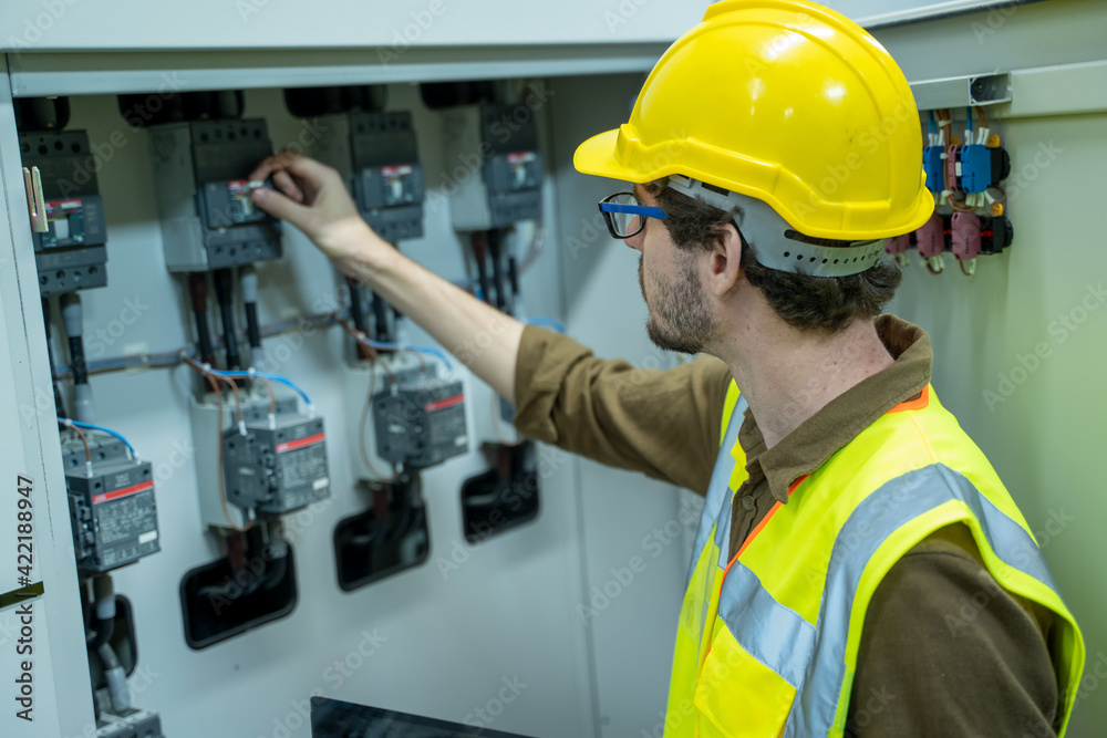 Electrical engineer checking status switchgear electrical energy distribution substation in factory.