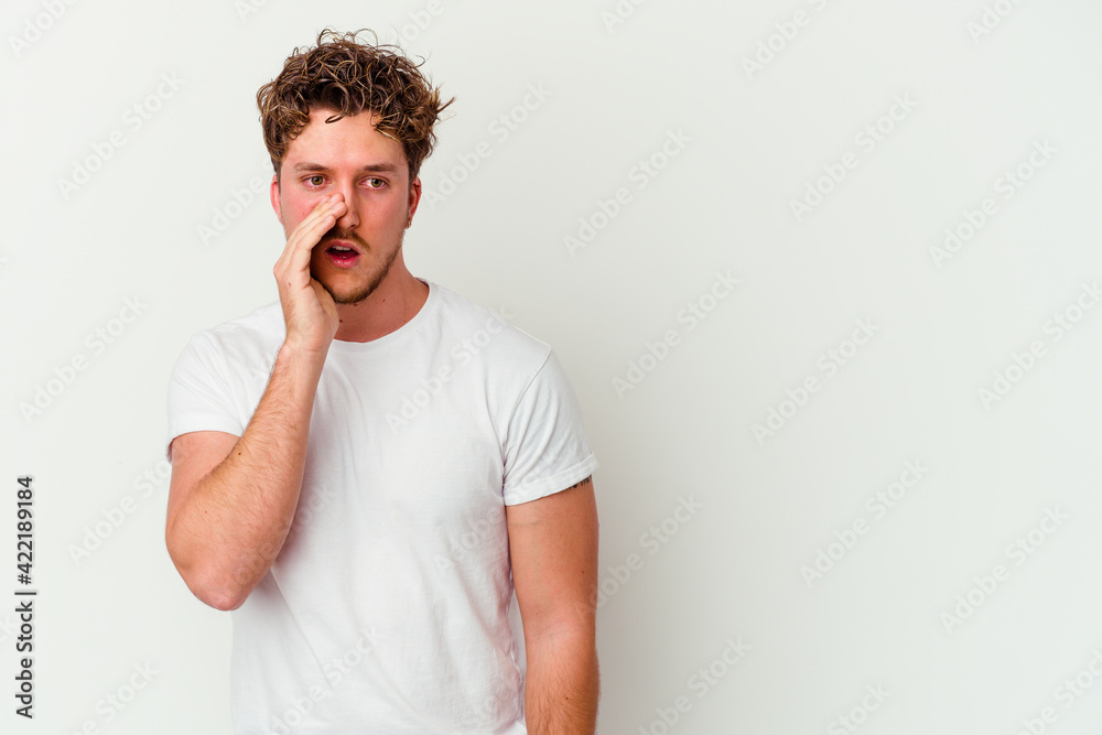 Young caucasian man isolated on white background is saying a secret hot braking news and looking aside Young caucasian man isolated on white background is saying a secret hot braking news and looking aside