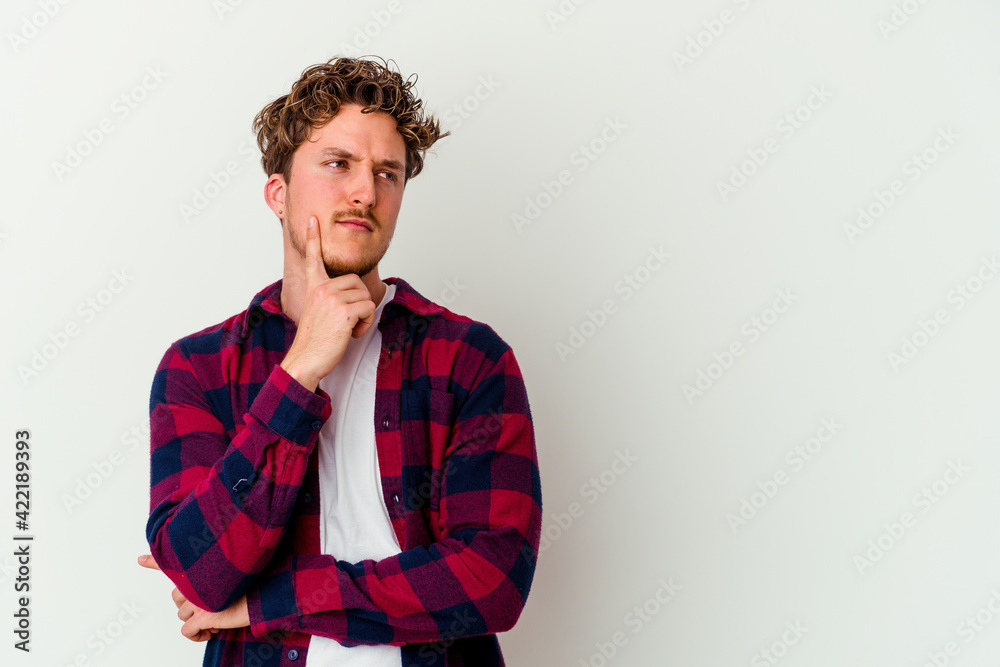 Obraz premium Young caucasian man isolated on white background looking sideways with doubtful and skeptical expression.