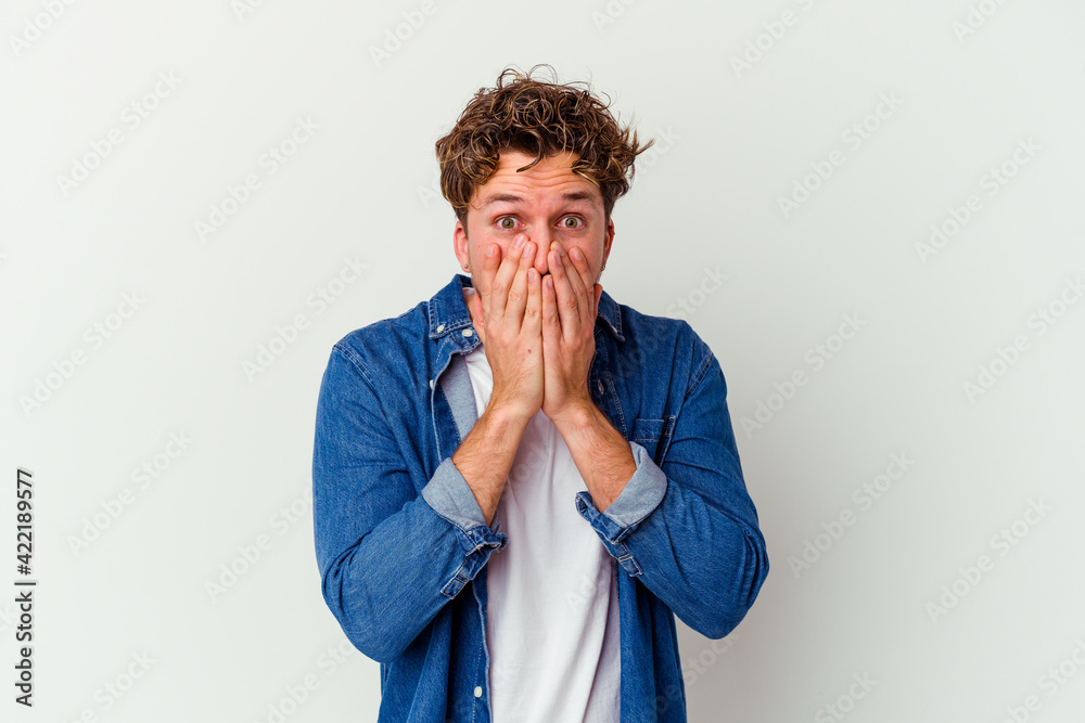 Young caucasian man isolated on white background shocked, covering mouth with hands, anxious to discover something new. Young caucasian man isolated on white background shocked, covering mouth with hands, anxious to discover something new.