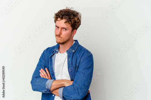 Young caucasian man isolated on white background unhappy looking in camera with sarcastic expression. © Asier
