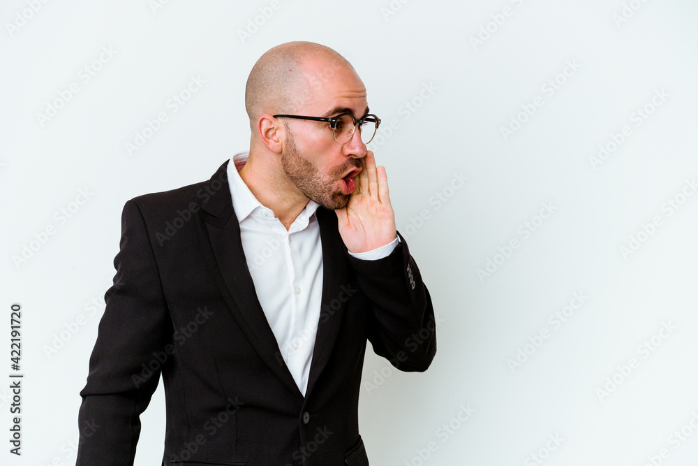 Young business caucasian bald man isolated on blue background is saying a secret hot braking news and looking aside Young business caucasian bald man isolated on blue background is saying a secret hot braking news and looking aside