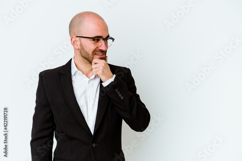 Young business caucasian bald man isolated on blue background touching back of head, thinking and making a choice.