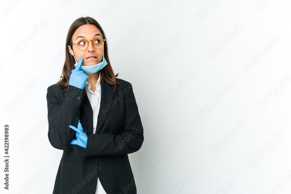 Young business latin woman wearing a mask to protect from covid isolated on white background relaxed thinking about something looking at a copy space. Young business latin woman wearing a mask to protect from covid isolated on white background relaxed thinking about something looking at a copy space.